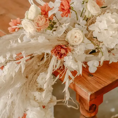 Close-up of dried pampas grass with peach roses and rust carnation