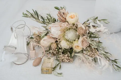 Bridal getting-ready flatlay with a dried protea and pampas bouquet