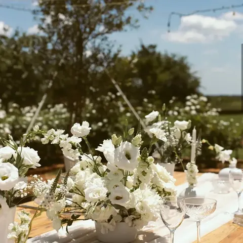 Close centerpiece of white lisianthus, stock and veronica on a reception table