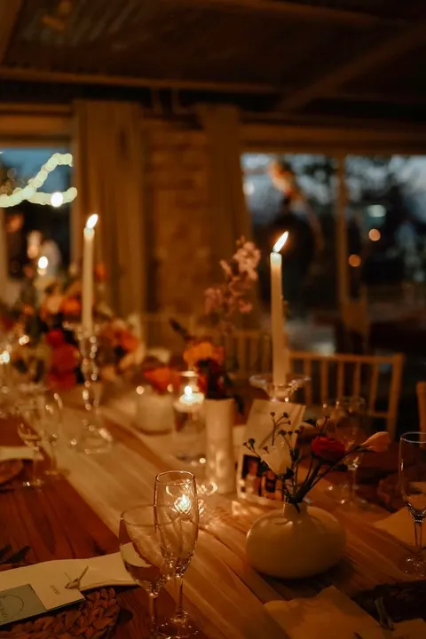 Evening candlelit table with warm-toned bud vase florals