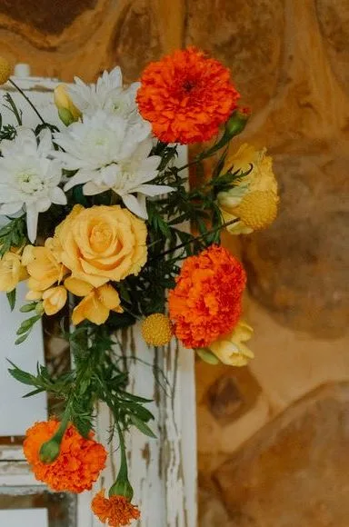 Marigold, rose and chrysanthemum spray on a weathered window frame