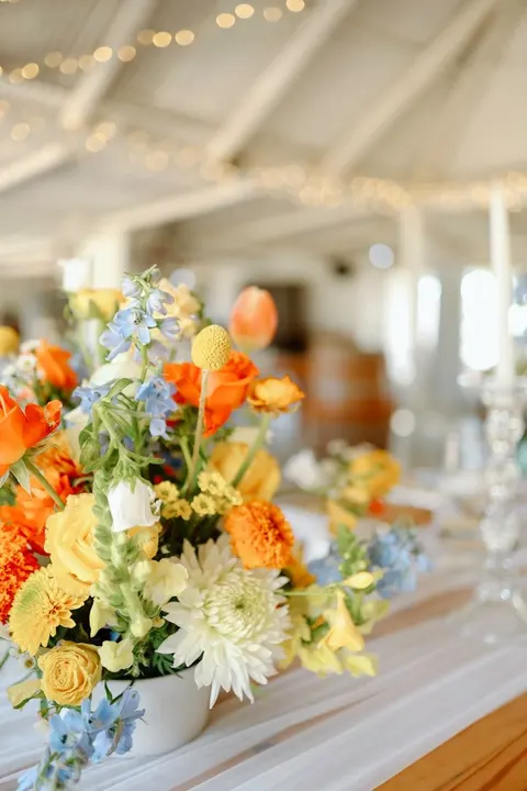 Close detail of an orange, yellow and blue wildflower centerpiece