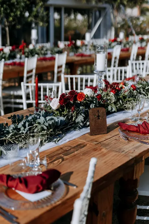 Place setting with a red taper candle and a red-and-white floral runner