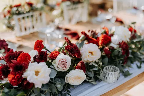 Macro detail of red and white roses with dahlias and eucalyptus