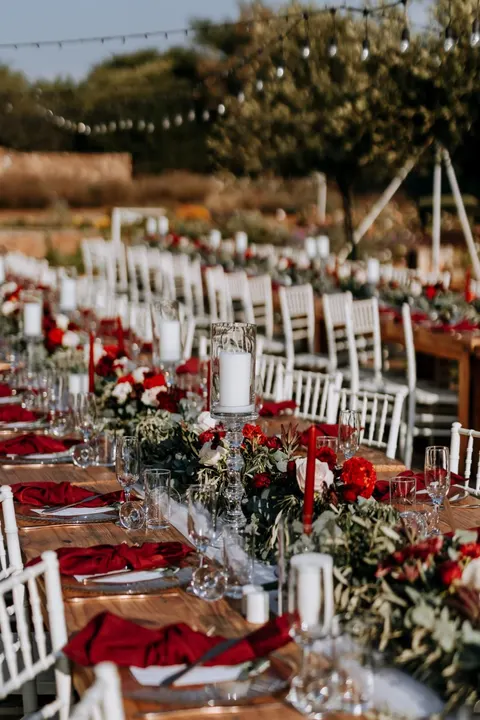 Candlelit reception tables dressed in red and white garlands