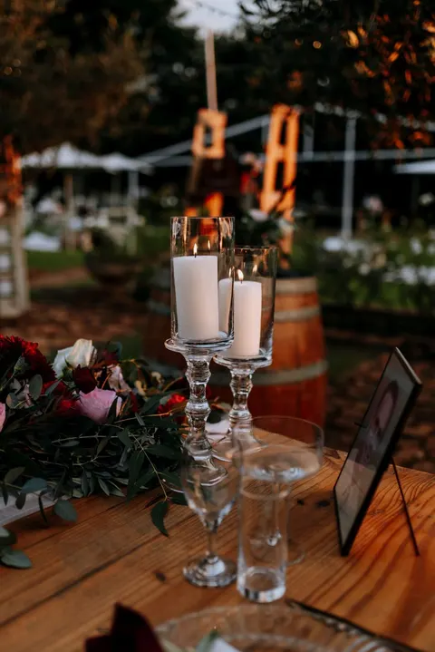 Dusk table detail with glass candle holders and red and pink roses