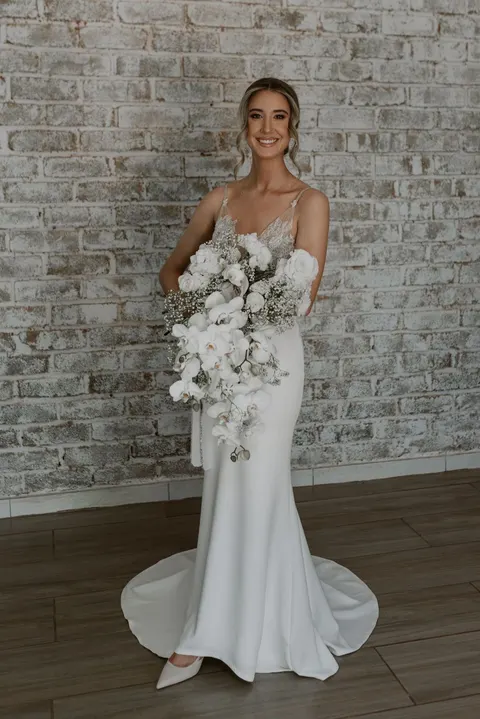 Bride portrait with a cascading white rose and orchid bouquet