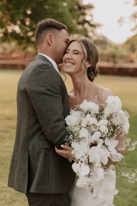 Couple portrait with a cascading white orchid bouquet