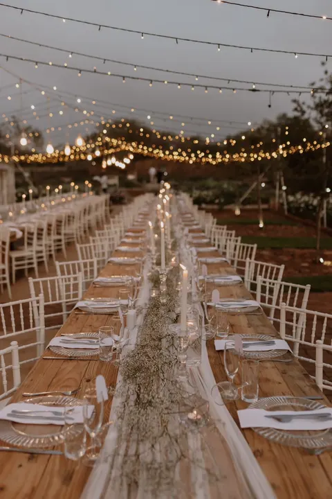 Reception tables dressed with baby's breath runners at dusk