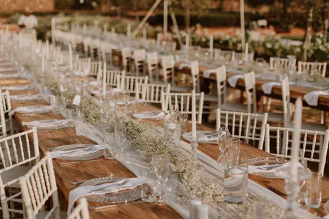 Reception tables dressed with baby's breath runners in daylight